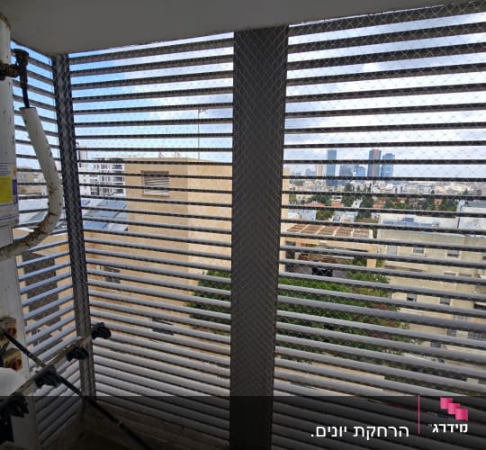 רשת מתכת על חלון למניעת כניסת יונים